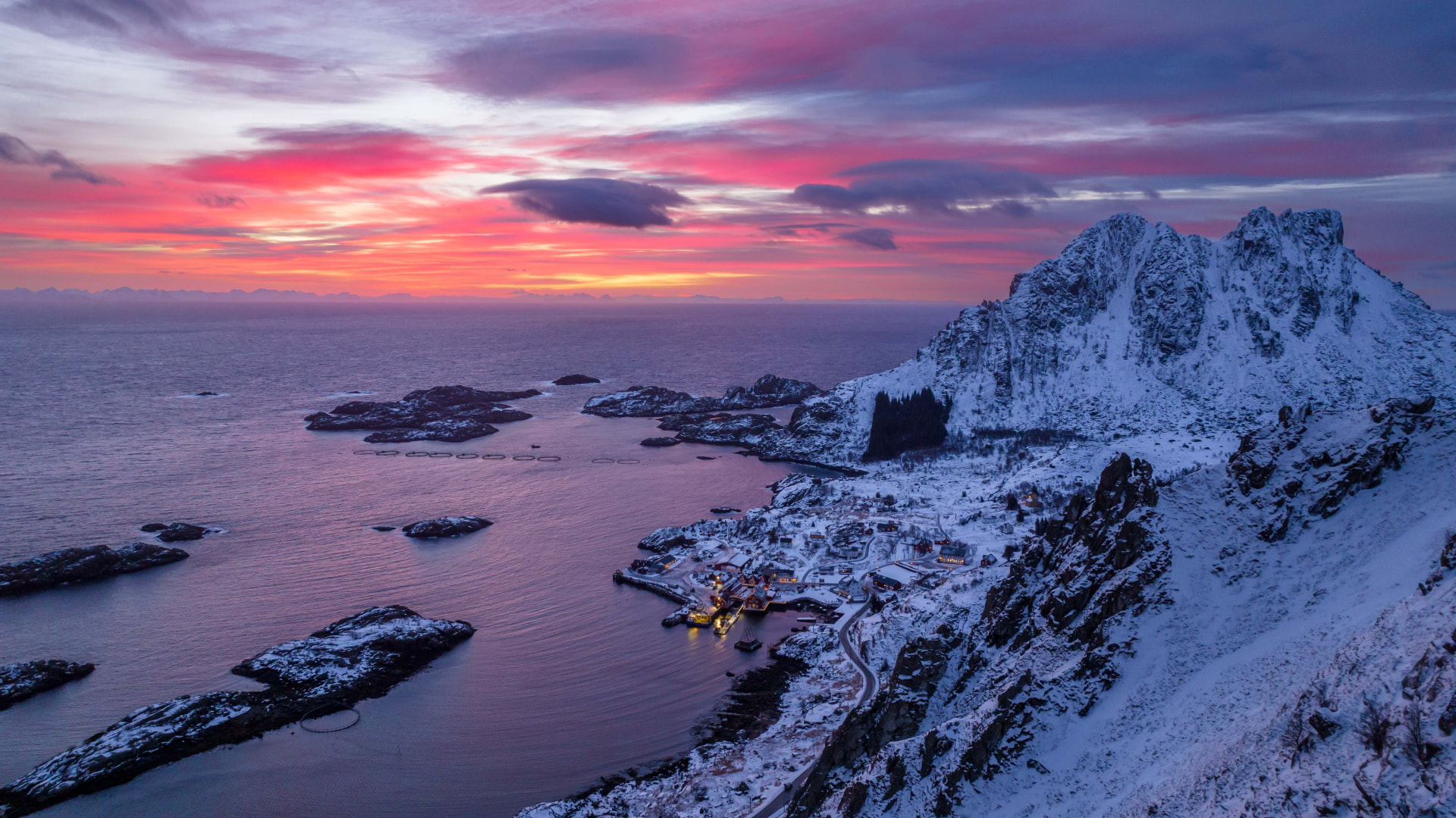 Ure village and its harbour beneath snow-covered Lofoten peaks at sunset